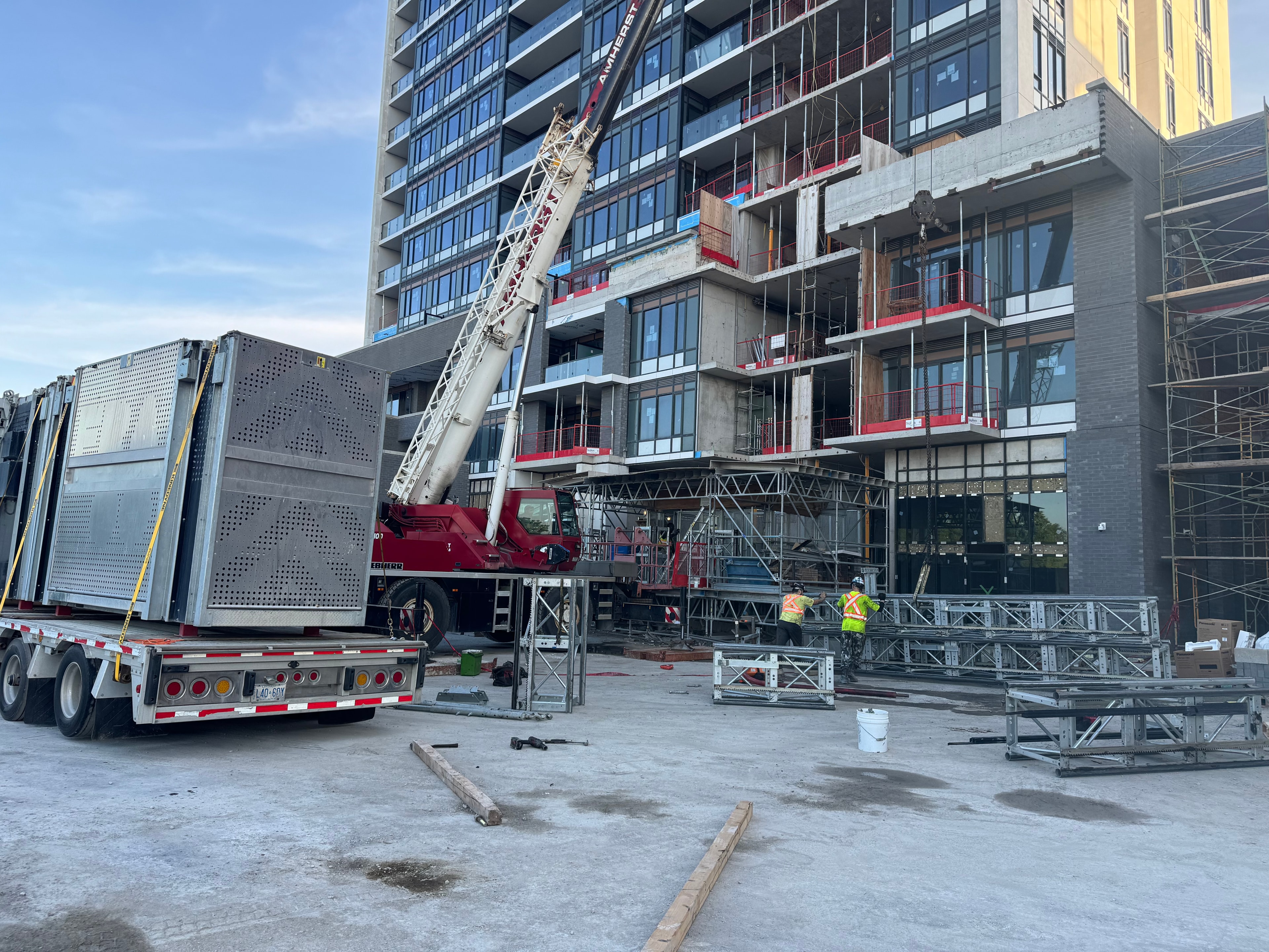 Crane lifting elevator components on active construction site